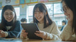 © Miljan Živković - teenage japanese girls education students using tablet in classroom
