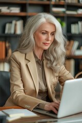 Wall Mural - A professional and gorgeous businesswoman typing on a laptop, embodying a modern and attractive lifestyle.