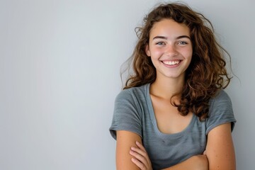 Poster - Young woman with a cheerful expression and folded arms, white background , background blur