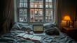 © milanchikov - Dormitorio en un interior real con una cama desordenada, un portátil, libros y una taza de café. La ventana muestra la vista de un edificio urbano al atardecer, creando un ambiente de trabajo relajado