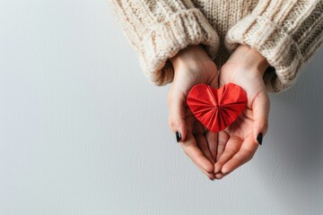 Wall Mural - A woman holds a red paper heart in her hands, ready for Valentine's Day or expressing love