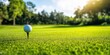 © Kamonwan - Close-up of a golf ball on a tee in a lush green landscape under a bright sky, perfect for sports and leisure themes.