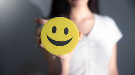 Wall Mural - young girl holding smiley face on her hand