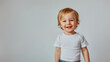© Taras Vykhopen - Happy white toddler smiling joyfully on white background during a bright afternoon