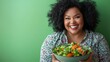 © เลิศลักษณ์ ทิพชัย - A joyful, plus-size woman holding a salad bowl and laughing, standing against a green background, representing healthy eating and a balanced lifestyle.