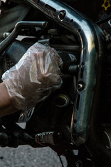 hand replaces the oil filter on the motorcycle and looks at all the details