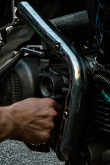 hand replaces the oil filter on the motorcycle and looks at all the details