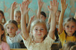 © Riva - Little children raising hands up and having fun in class