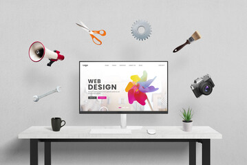 Leinwandbilder - Web design concept page displayed on computer in studio, surrounded by creative, marketing, and office tools flying around. Concept of the creative process in a modern design studio environment