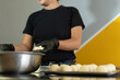 © Andrey - woman baker kneads the shape of the bunuelos or cheese breads that are ready to be fried.