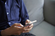 © Wanda - Man using smartphone chatting, checking social media by touch screen, He sitting on sofa in living room at home