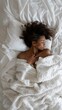 © liliyabatyrova - A woman is sleeping in bed with a white blanket covering her