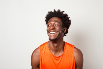 Wall Mural - Portrait of a grinning afro-american man in his 20s sporting a breathable mesh jersey in front of white background