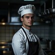© Eduards V. - Professional chef in uniform standing confidently in restaurant kitchen