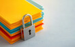 © Anatthaphon - Colorful folders secured with padlock, symbolizing data protection and privacy in an office environment.