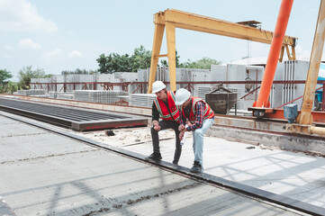 Engineer and foreman worker team checking project at precast factory site, Engineer and builders in hardhats discussing on construction site