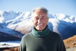 © Markus Schröder - Portrait of a smiling man in his 70s wearing a classic turtleneck sweater in snowy mountain range