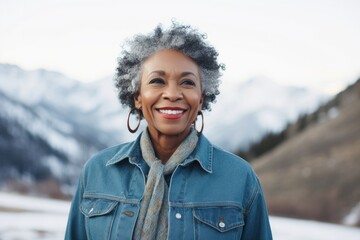 Poster - Portrait of a merry afro-american woman in her 60s sporting a versatile denim shirt on snowy mountain range