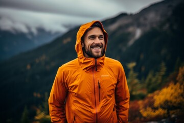 Sticker - Portrait of a happy man in his 30s wearing a windproof softshell in backdrop of mountain peaks