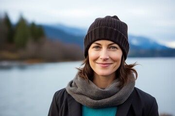 Poster - Portrait of a satisfied woman in her 40s donning a warm wool beanie on serene lakeside view