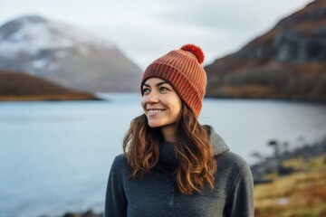 Poster - Portrait of a satisfied woman in her 40s donning a warm wool beanie in serene lakeside view