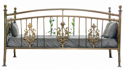 A decorative metal daybed with floral designs and soft pillows, suitable for relaxation.