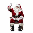 © Mykola - Santa Claus sitting in a chair and waving his hand, isolated on white