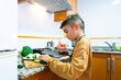 © Arianne - Boy cutting vegetables in the kitchen at home. healthy lifestyle