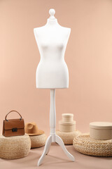 Sticker - One female mannequin, poufs, bag, hat and boxes on beige background