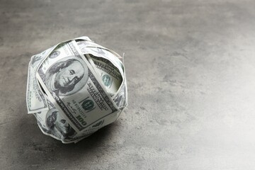 Sticker - Ball made of dollars on grey table. Space for text