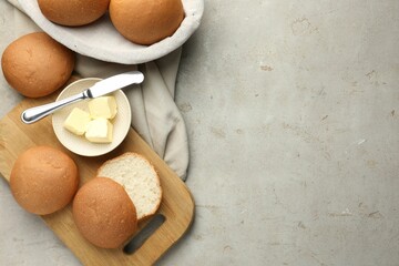 Wall Mural - Fresh tasty buns and butter on grey table, top view. Space for text