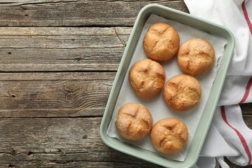 Wall Mural - Homemade tasty buns in baking dish on wooden table, top view. Space for text