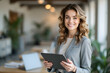 © Amir Bajric - business smiling woman in the office holding a tablet