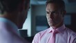 © Kakabe - A man in a polished pink shirt and tie stares intently into a mirror, conveying confidence and determination, Ideal for business-related themes, leadership, or personal development visuals,