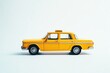 © Fotograf - A small yellow toy car sits on a clean white surface, perfect for illustration or design projects