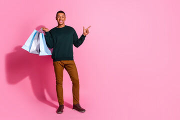 Wall Mural - Full length photo of funky cool guy dressed pullover rising bargains pointing emtpy space isolated pink color background