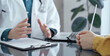© volha_r - Doctor and patient consultation in clinic. Patient listens attentively as a doctor explains a diagnosis in a modern medical office, close up. Medicine and health care