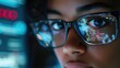 © Kitta - Close-up of a focused individual wearing glasses, reflecting digital data on their lenses, showcasing concentration and technology.