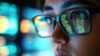 © Kitta - Close-up of a person wearing glasses, reflecting vibrant code and technology, symbolizing innovation and digital expertise.