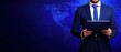 © Watercolor_Kawaii - A businessman in a suit standing with a tablet, against a digital blue world map background, conveying professionalism and modern technology.