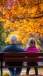 © AURA COLLECTIONS - A grandparent and child sit on a bench under vibrant autumn foliage, enjoying nature together.