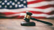 © Taras Vykhopen - Gavel resting on a wooden table with an American flag backdrop symbolizing justice in the courtroom