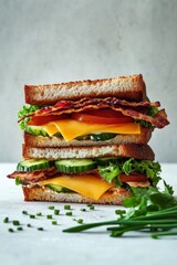 Sticker - Delicious stacked sandwich with bacon, cheese, and fresh vegetables on toasted bread