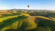 © 3r1k_ai - Colorful hot air balloons flying over green hill landscape