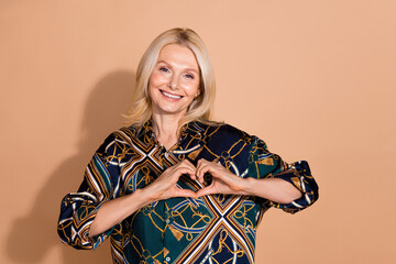 Sticker - Photo portrait of blonde hair happy mature business lady enjoy charity donations showing heart symbol isolated on beige color background