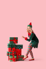 Wall Mural - Beautiful young woman dressed as elf with Christmas gifts on pink background