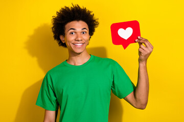 Poster - Photo of funky cool guy dressed green t-shirt rising heart like card emtpy space isolated yellow color background