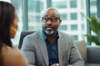 © wolfhound911 - A middle-aged African American bank manager discussing financial plans with a client in a contemporary office. The professional decor and modern furnishings enhance the collaborative environment.