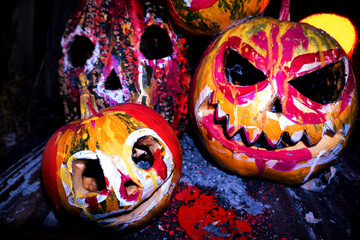 art scary Halloween with pumpkins and an old kerosene lamp in a red light preparation for the celebration in a dark room 