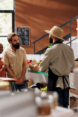 Canvas Print - Caucasian man and African American woman, are shopping in multicultural market. Emphasis is on promoting healthy lifestyle through availability of fresh, organic, and natural products.